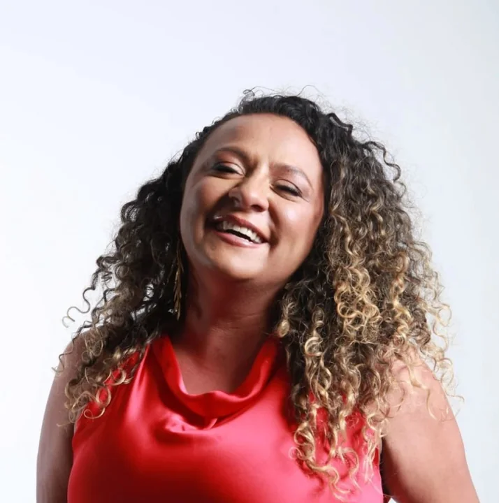 Diana Cortes sorrindo, usando uma blusa vermelha